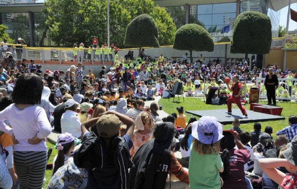 A large outdoor crowd gathered on a lawn for a public arts festival.